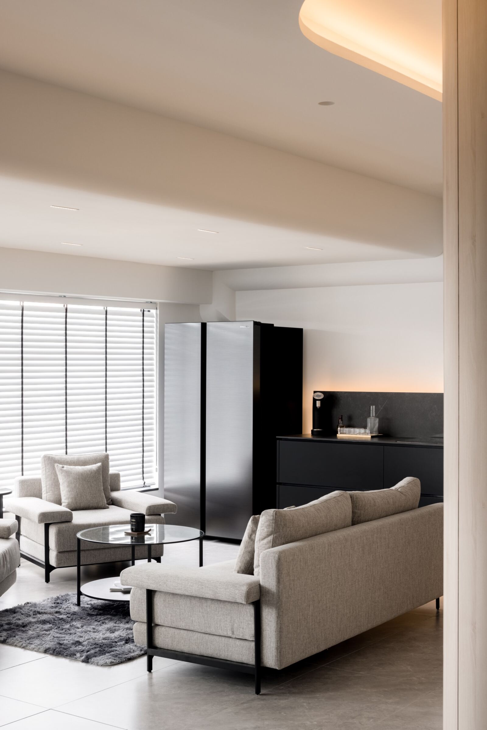 Gardens Showroom commercial interior with lounge seating, black cabinetry and curved ceiling lighting by The Local INN.terior